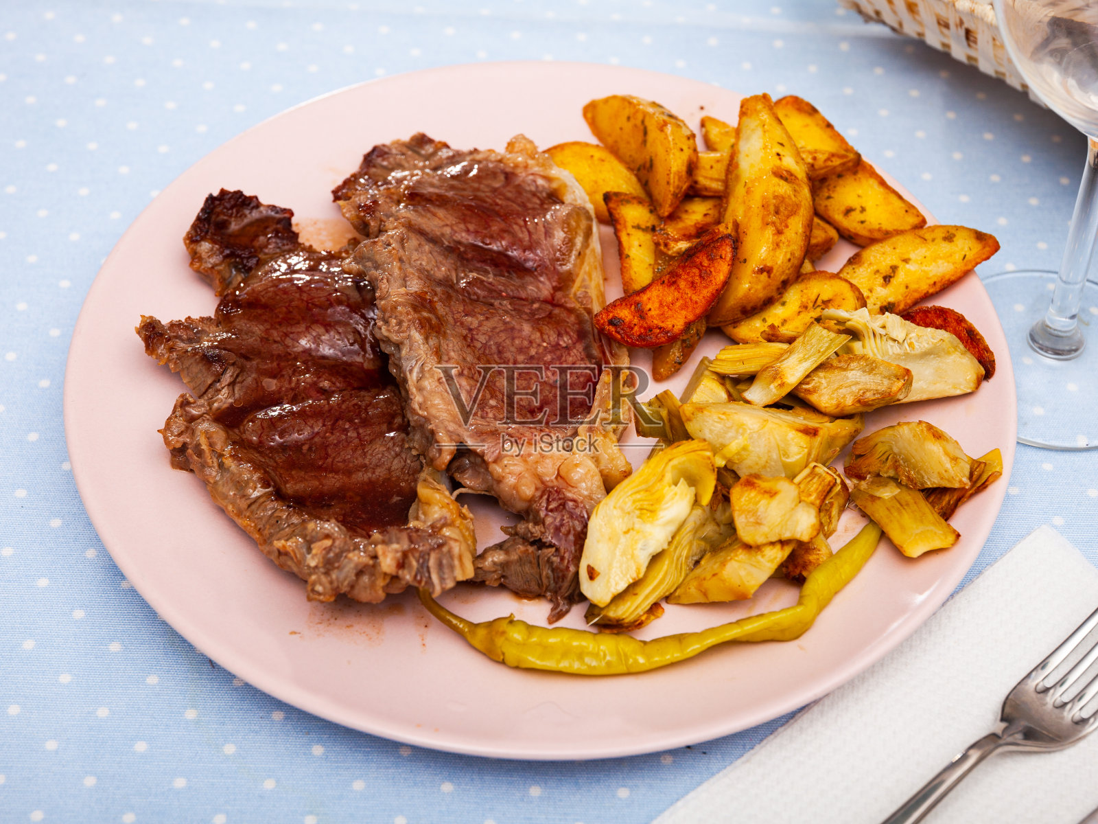 牛排配土豆和洋蓟放在木板上照片摄影图片