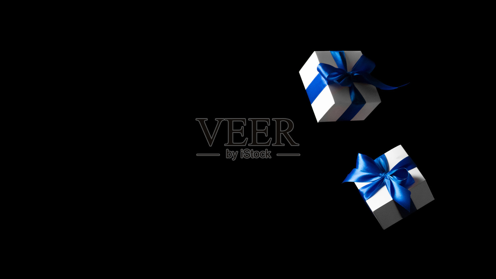 折扣的背景。黑色星期五的横幅是白色的礼物和蓝色的蝴蝶结落在黑色的背景上。飞行背景与文字空间。照片摄影图片