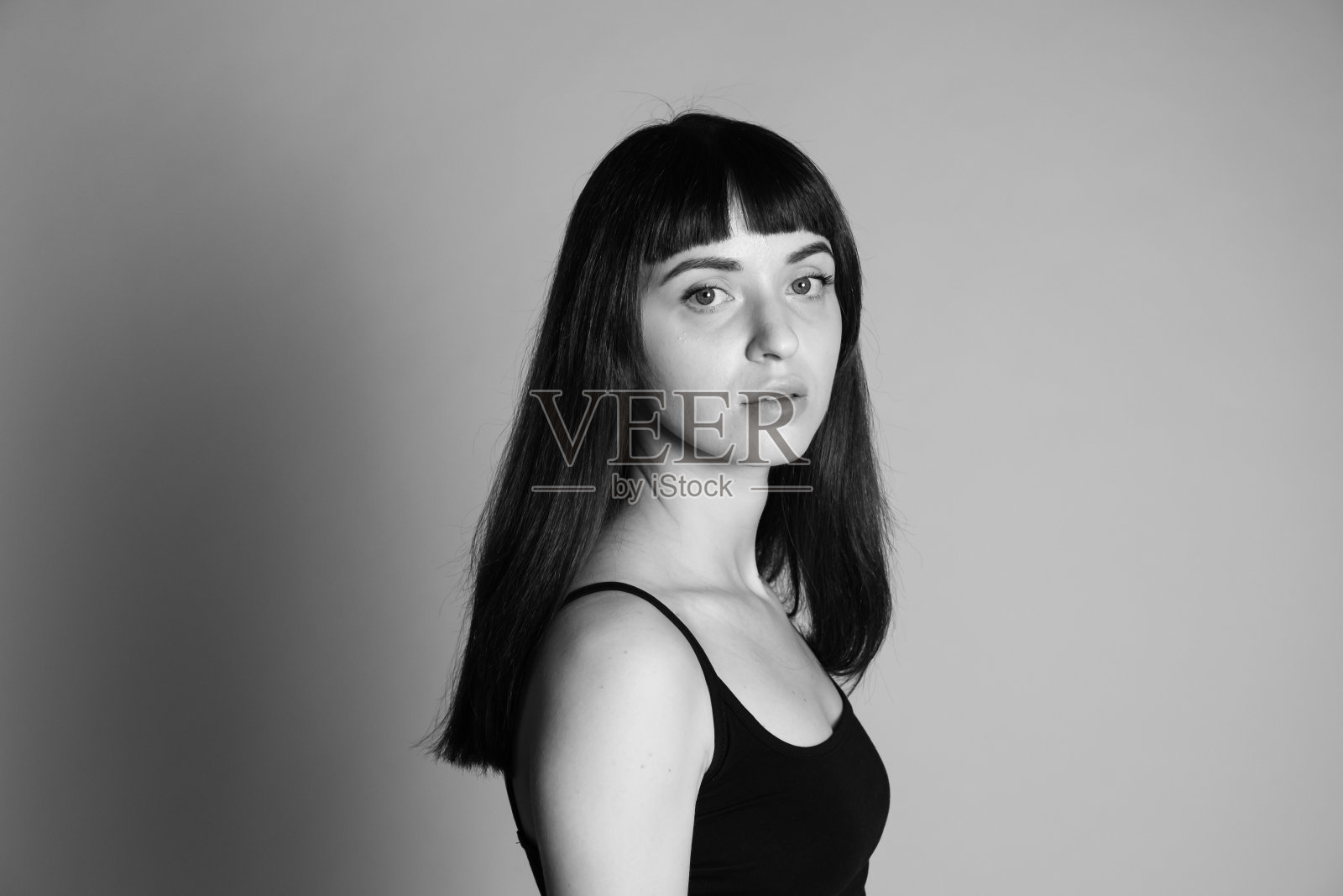 一个年轻女子的画室肖像,背景是纯灰色照片摄影图片