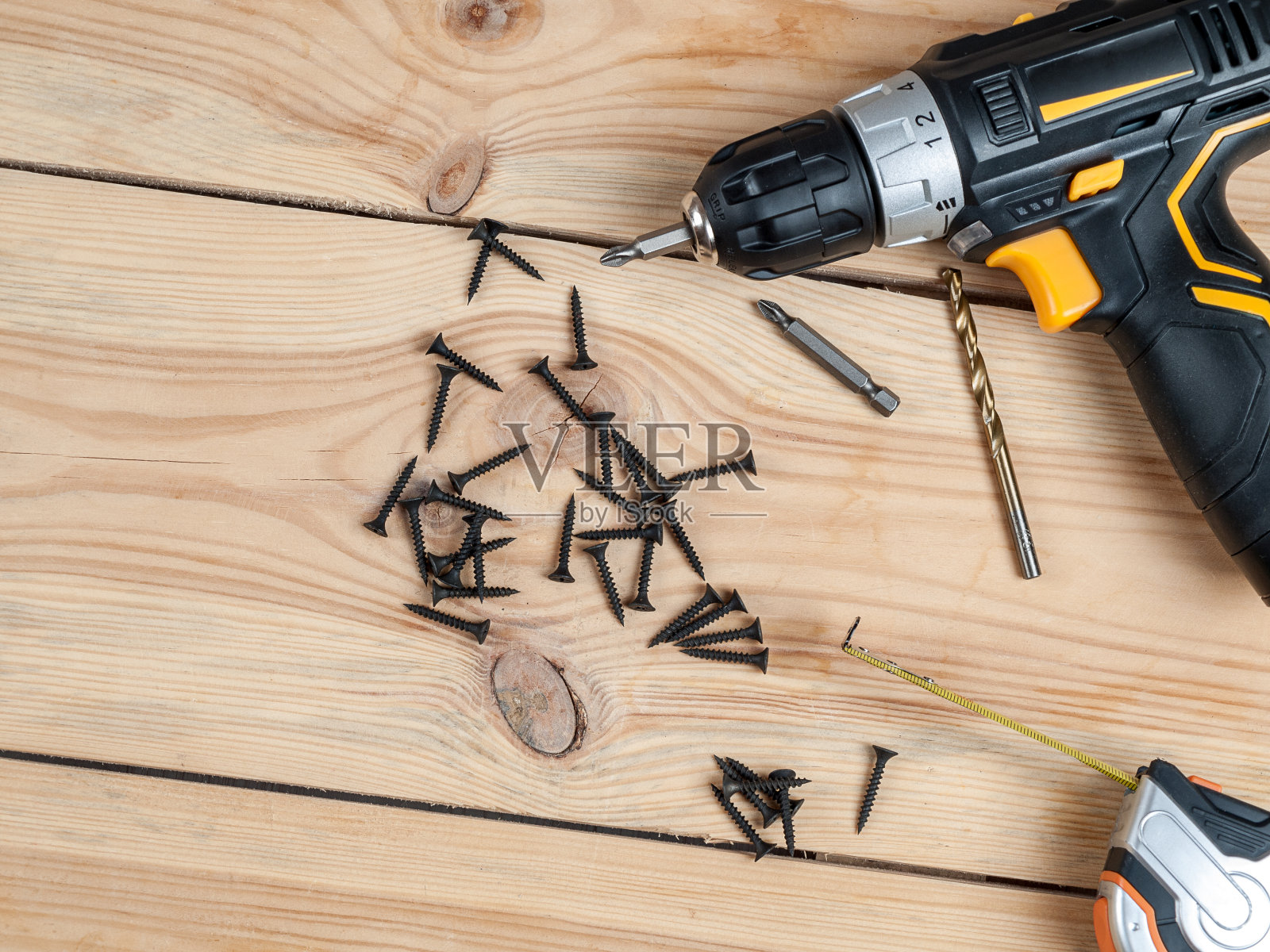 螺丝自攻螺丝背景上有一个螺丝刀,可为不同材料的墙体选择不同的自攻螺丝照片摄影图片