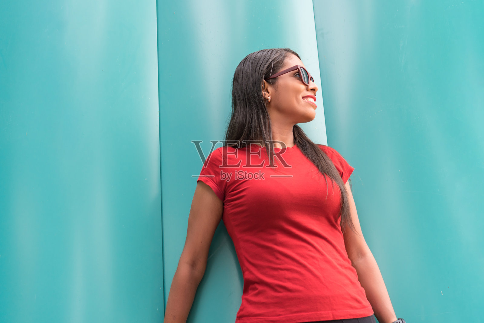 一个长头发的西班牙妇女的肖像靠在街上的一堵墙上照片摄影图片