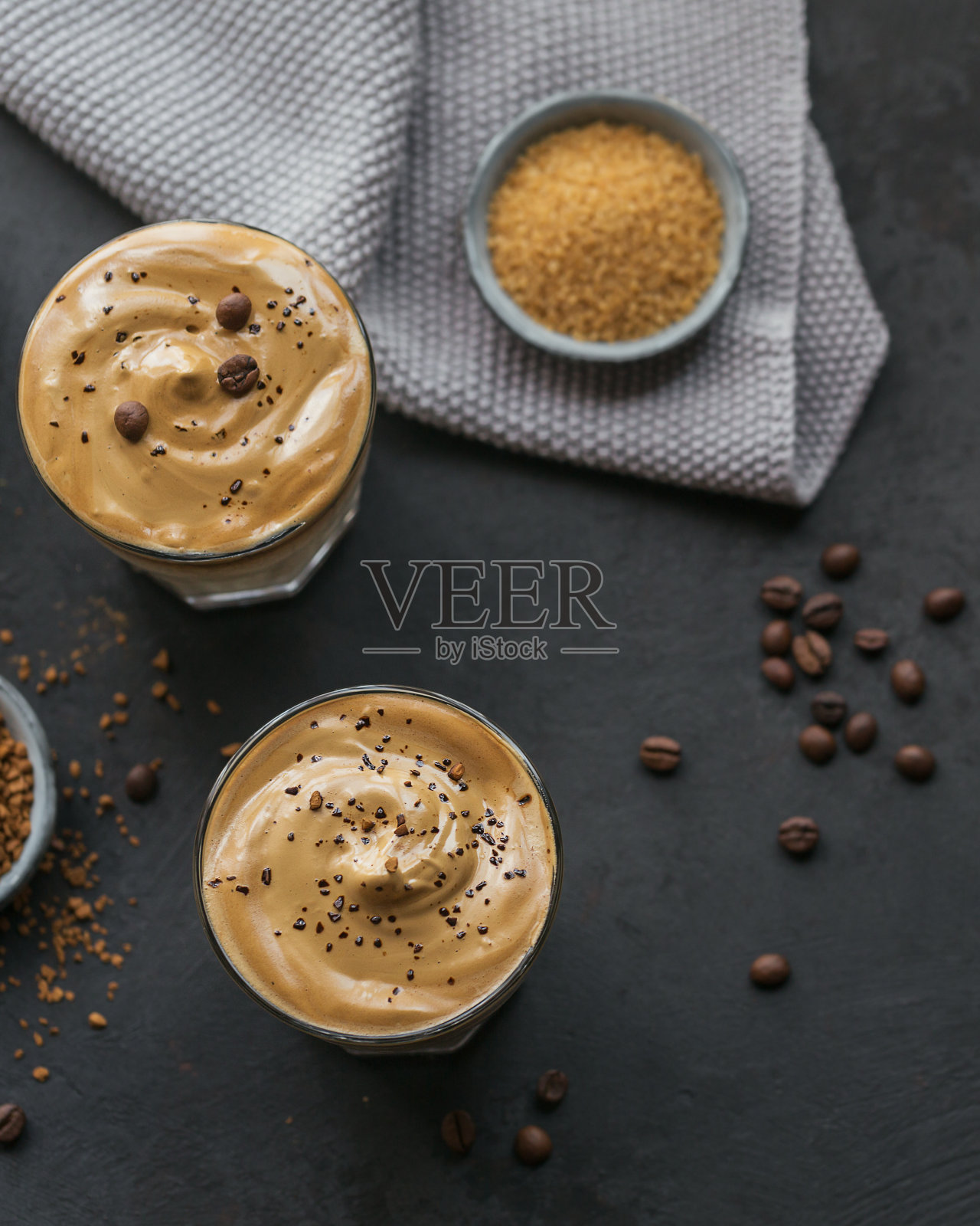 一杯冰达尔戈纳咖啡,时髦的蓬松奶油咖啡和牛奶在黑暗的背景。照片摄影图片