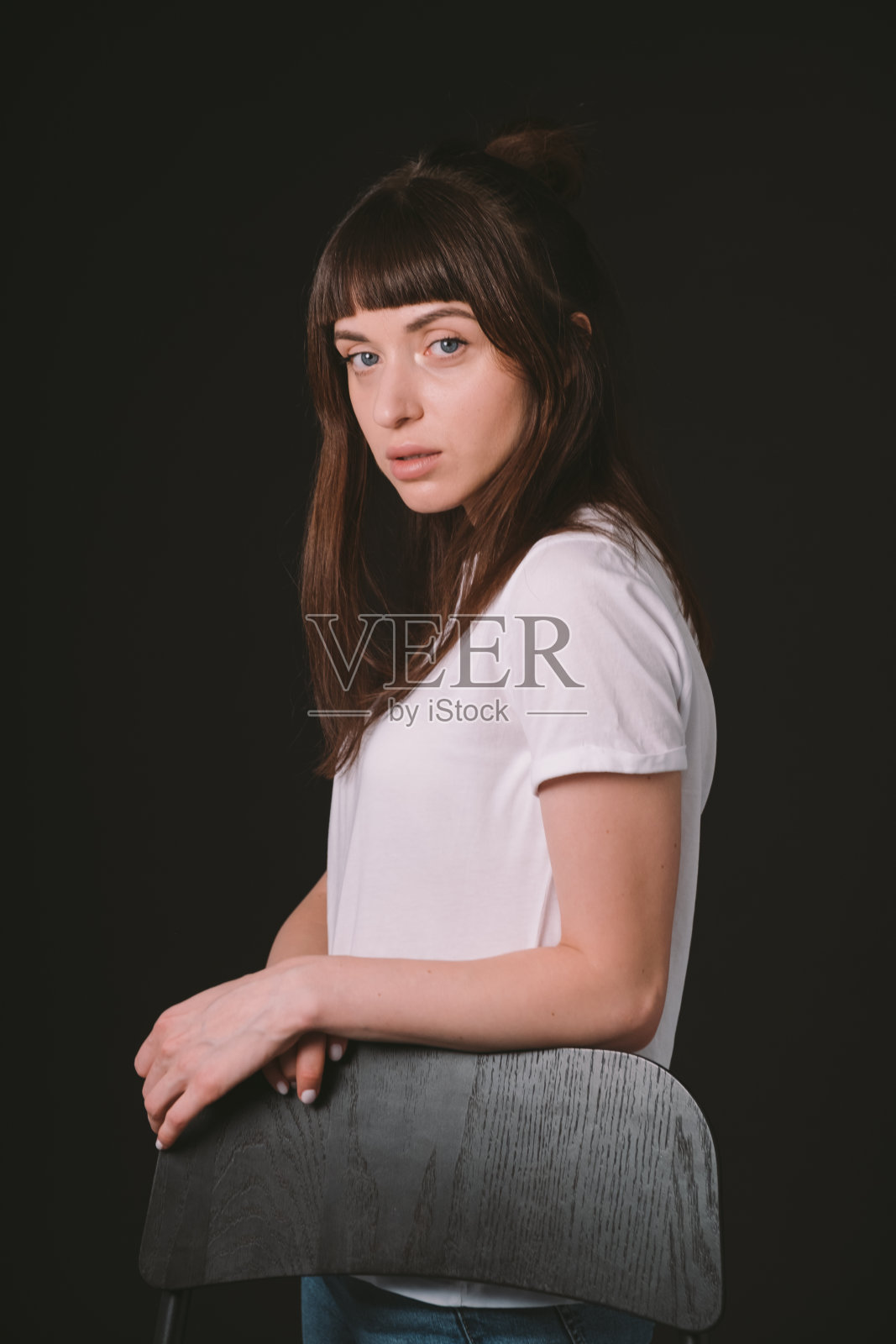 一个年轻女子的画室肖像,背景是纯黑色照片摄影图片