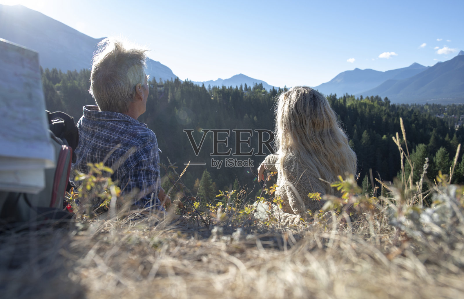 日出时,徒步旅行的夫妇在草地上休息照片摄影图片