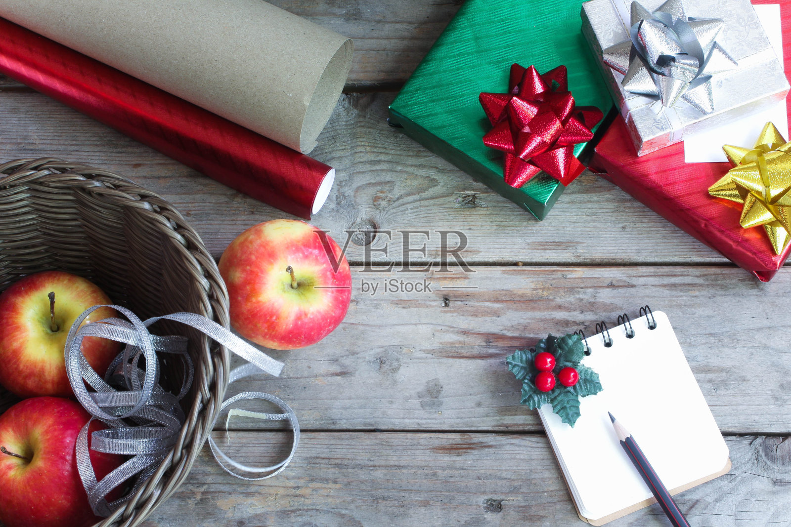红色和绿色的圣诞礼品盒和纸条放在木地板上照片摄影图片