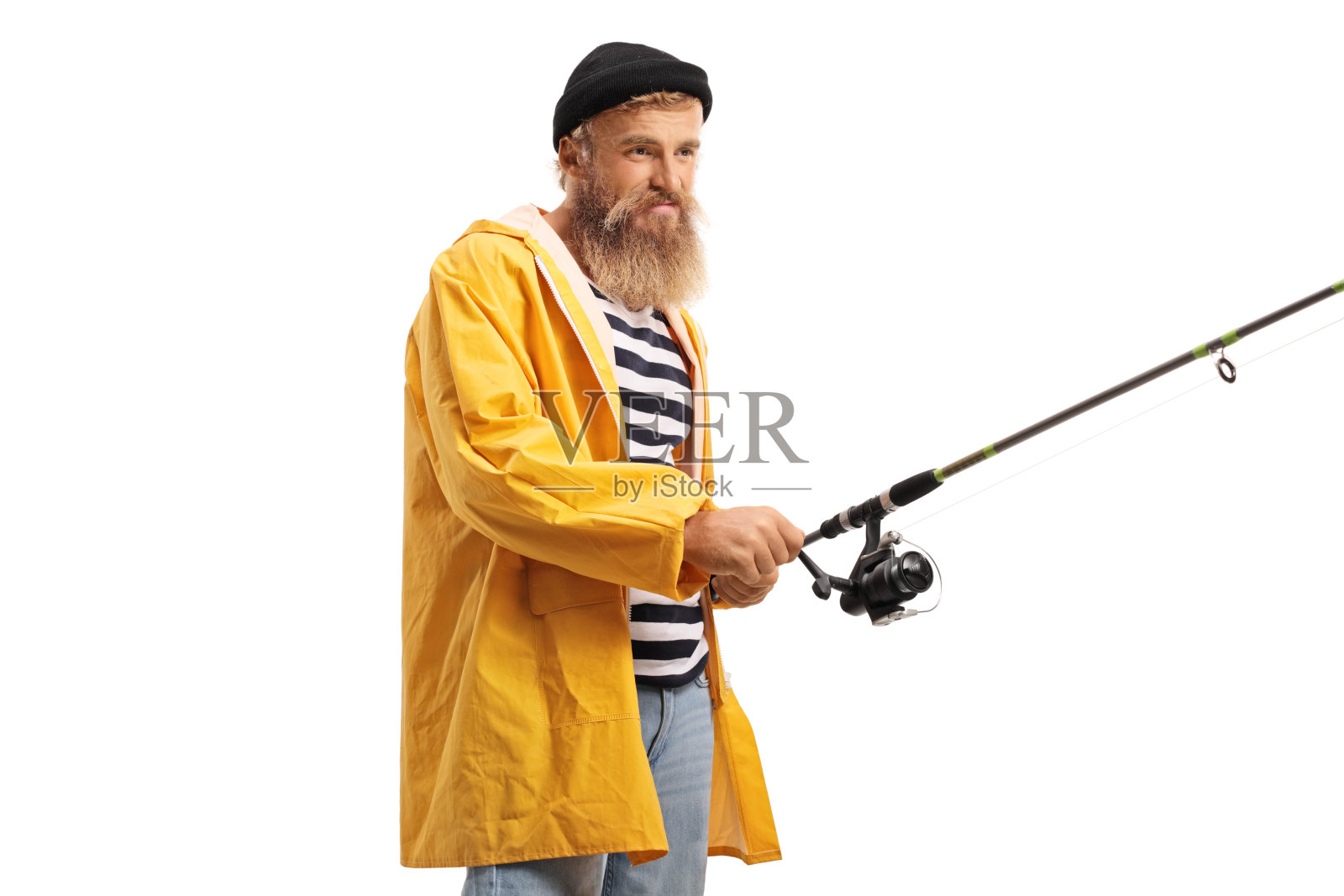 穿着黄色雨衣的年轻渔夫正在旋转钓竿上的卷轴照片摄影图片