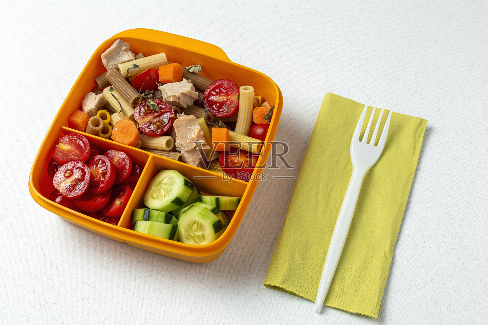 在工作场所吃午餐,午餐盒里装着金枪鱼、西红柿的健康意大利面照片摄影图片