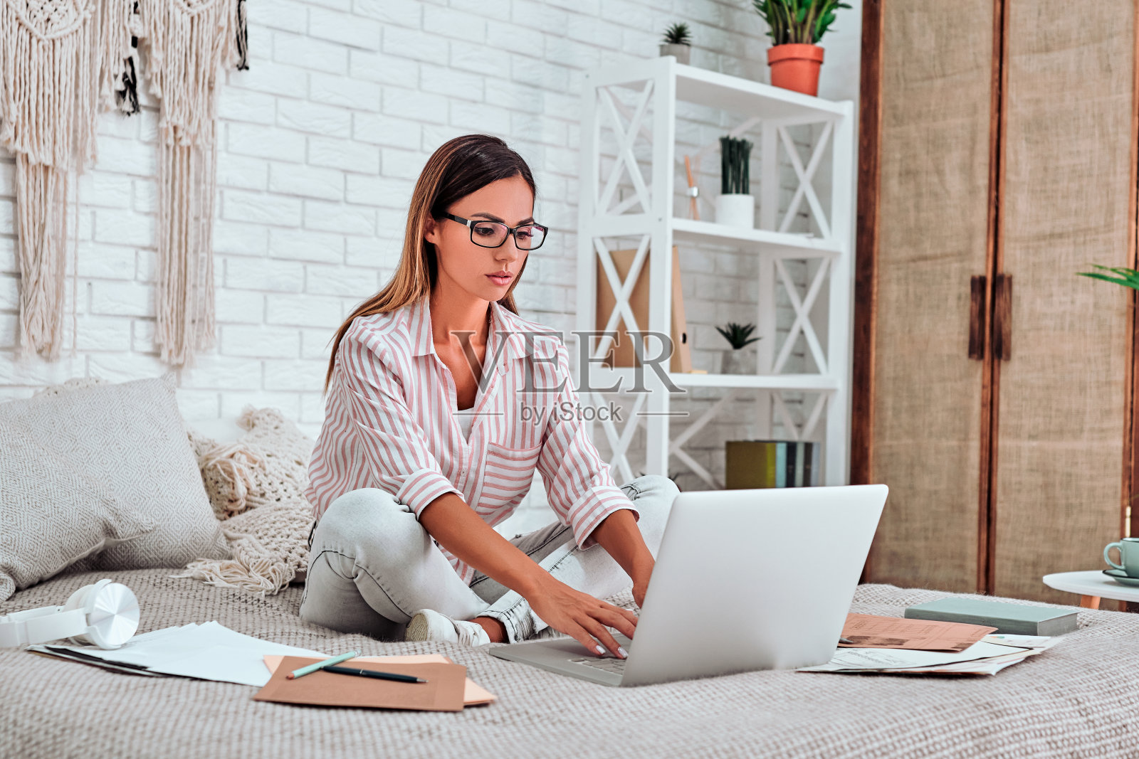 远程学习、在线教育和工作。快乐的女人女孩工作办公室远程工作在家床上。照片摄影图片