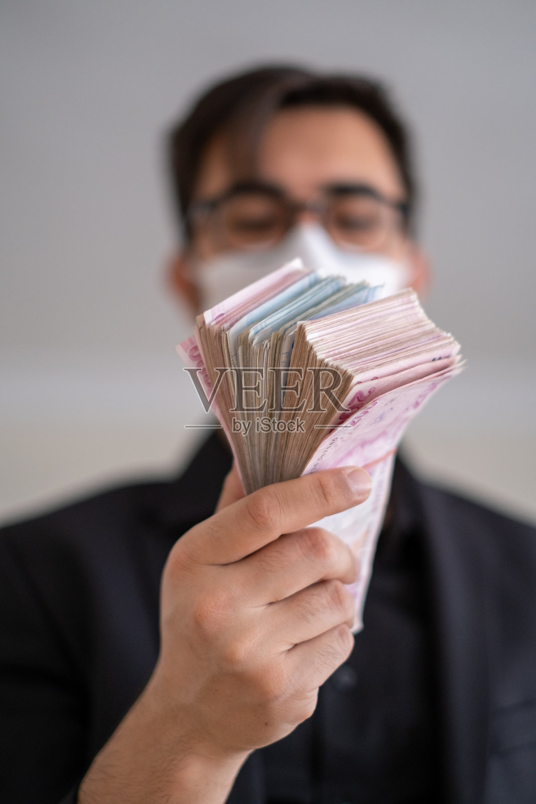 一名戴口罩的男子给土耳其人钱照片摄影图片