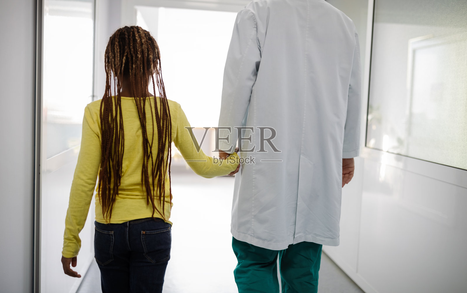 儿科医生和他的小女孩病人在医院微笑照片摄影图片