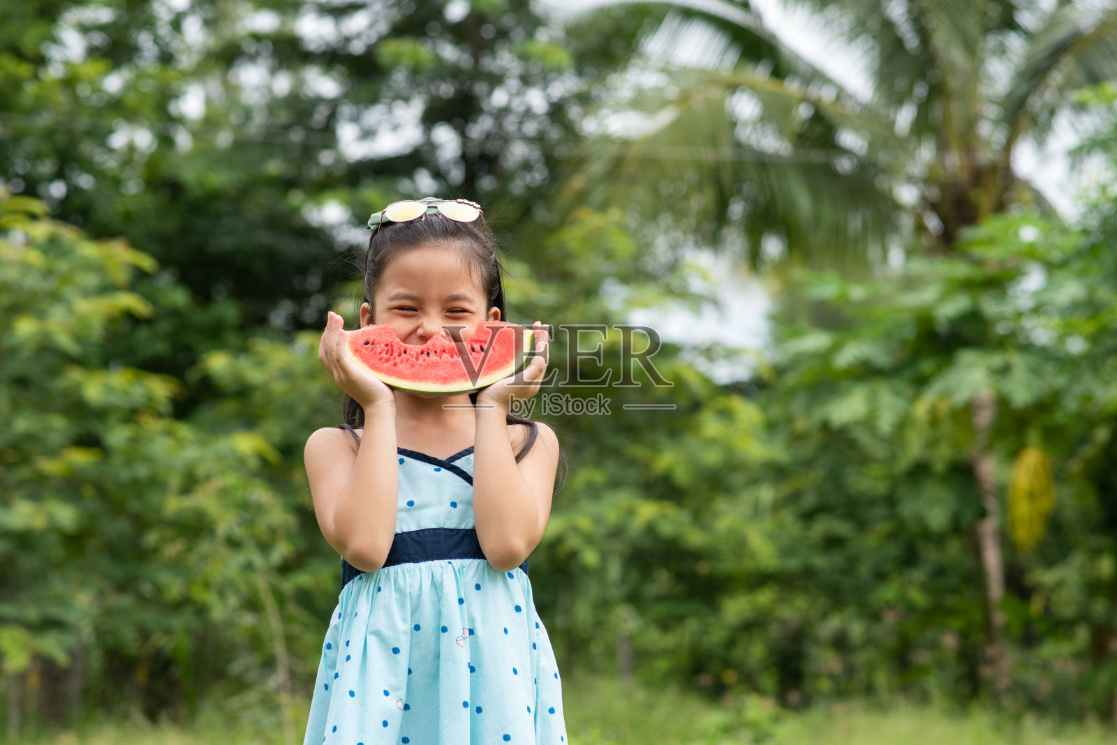 亚洲女孩站着,拿着西瓜照片摄影图片