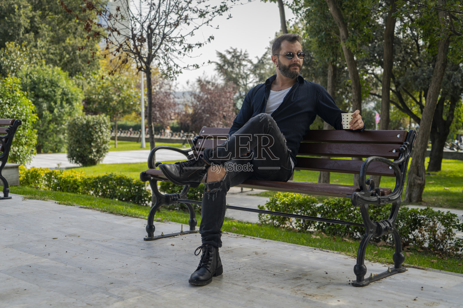 在公园里喝咖啡的男人照片摄影图片