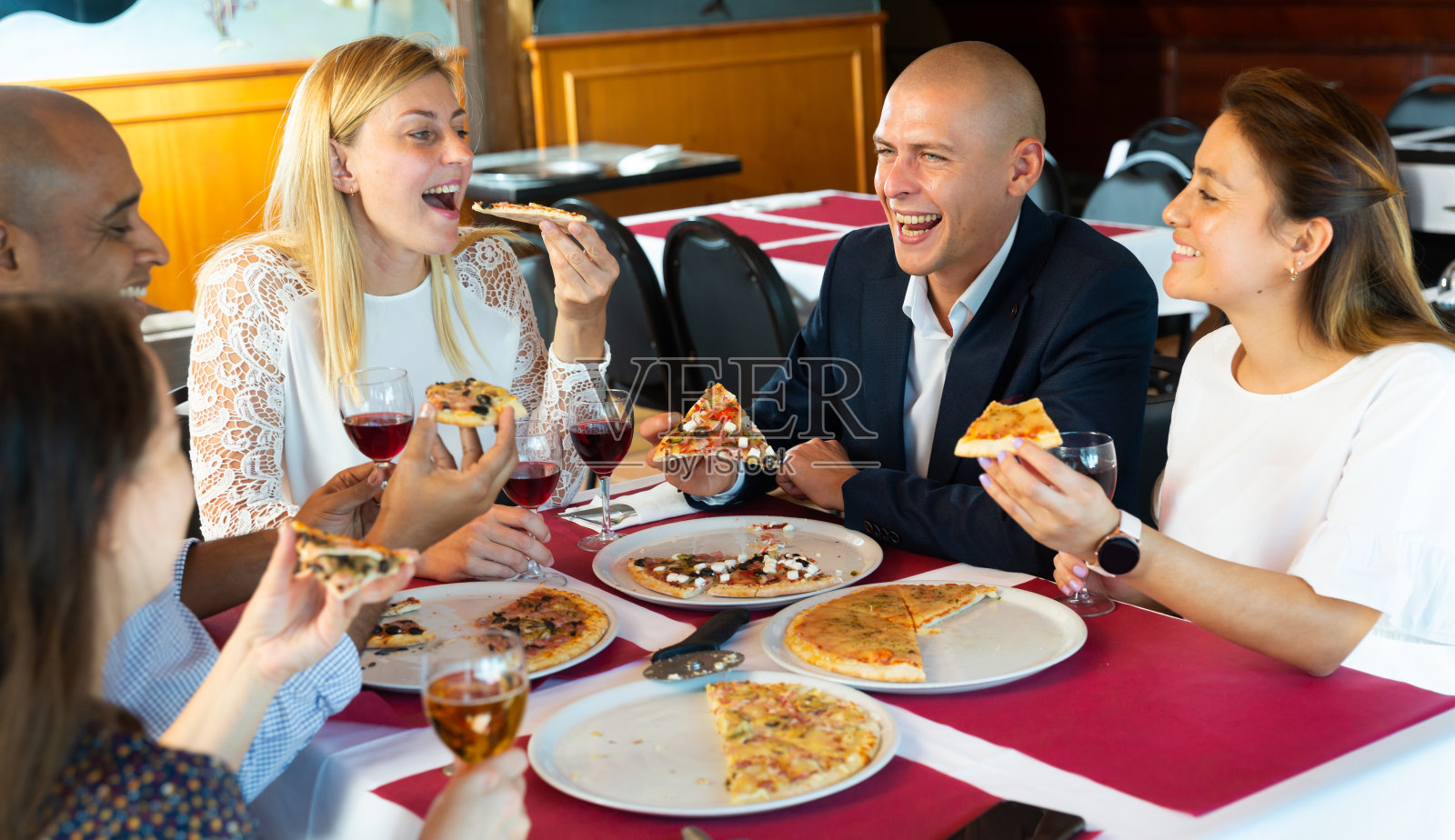 兴高采烈的年轻人在舒适的餐厅里享用披萨照片摄影图片