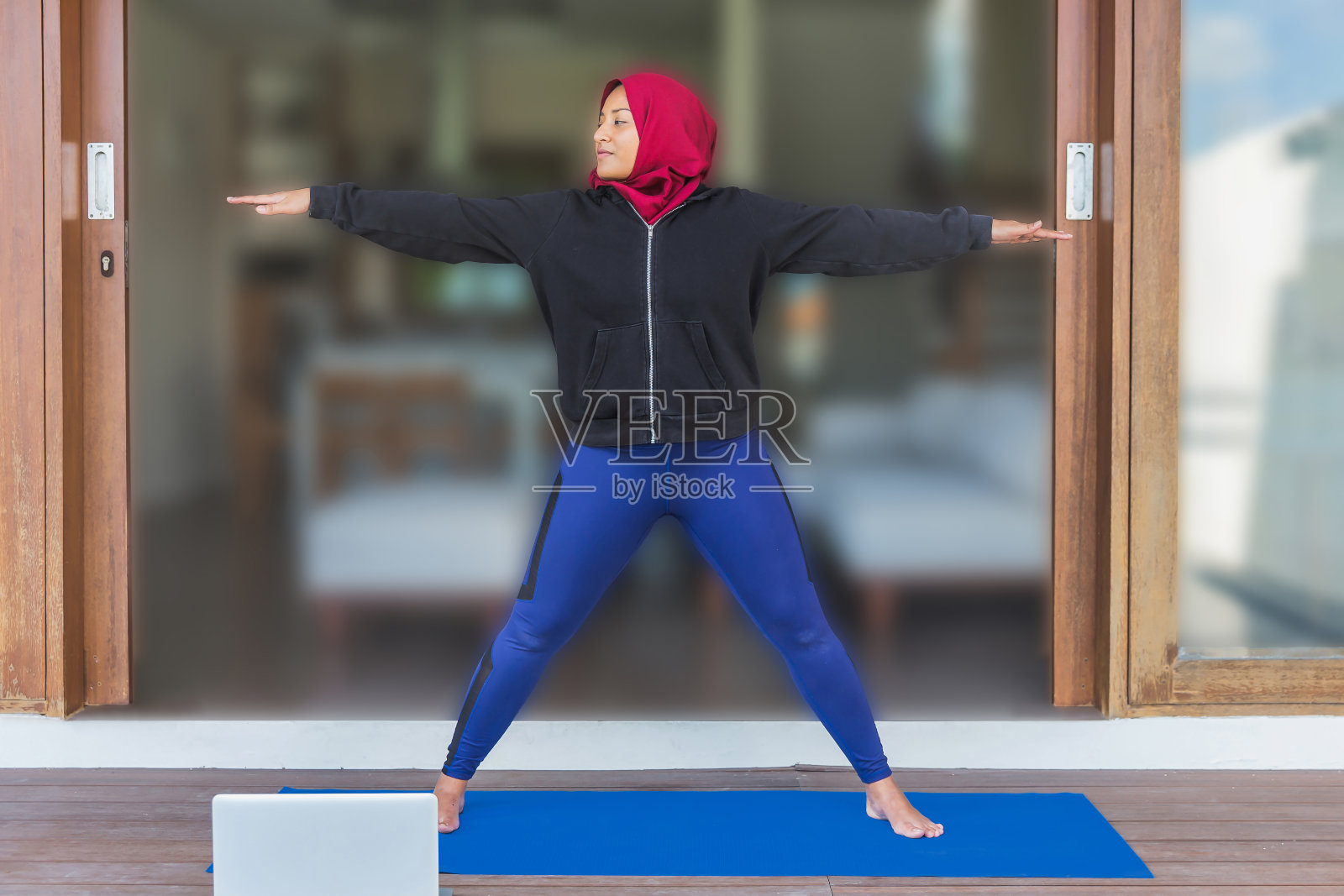 印度穆斯林健身教练开始她的晨间课程与伸展手臂照片摄影图片