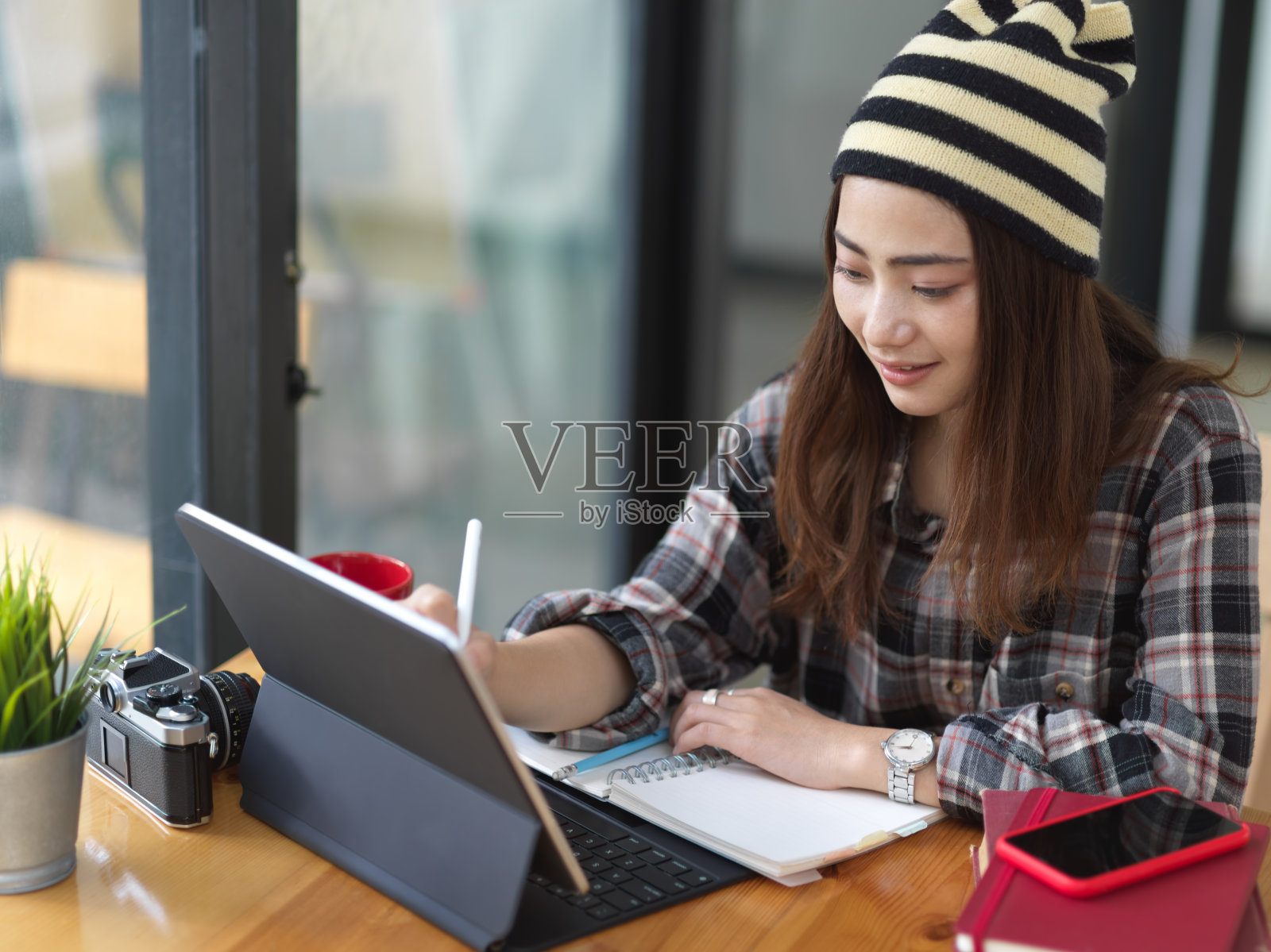 女性工作与写字板和文具在咖啡店的木桌上照片摄影图片