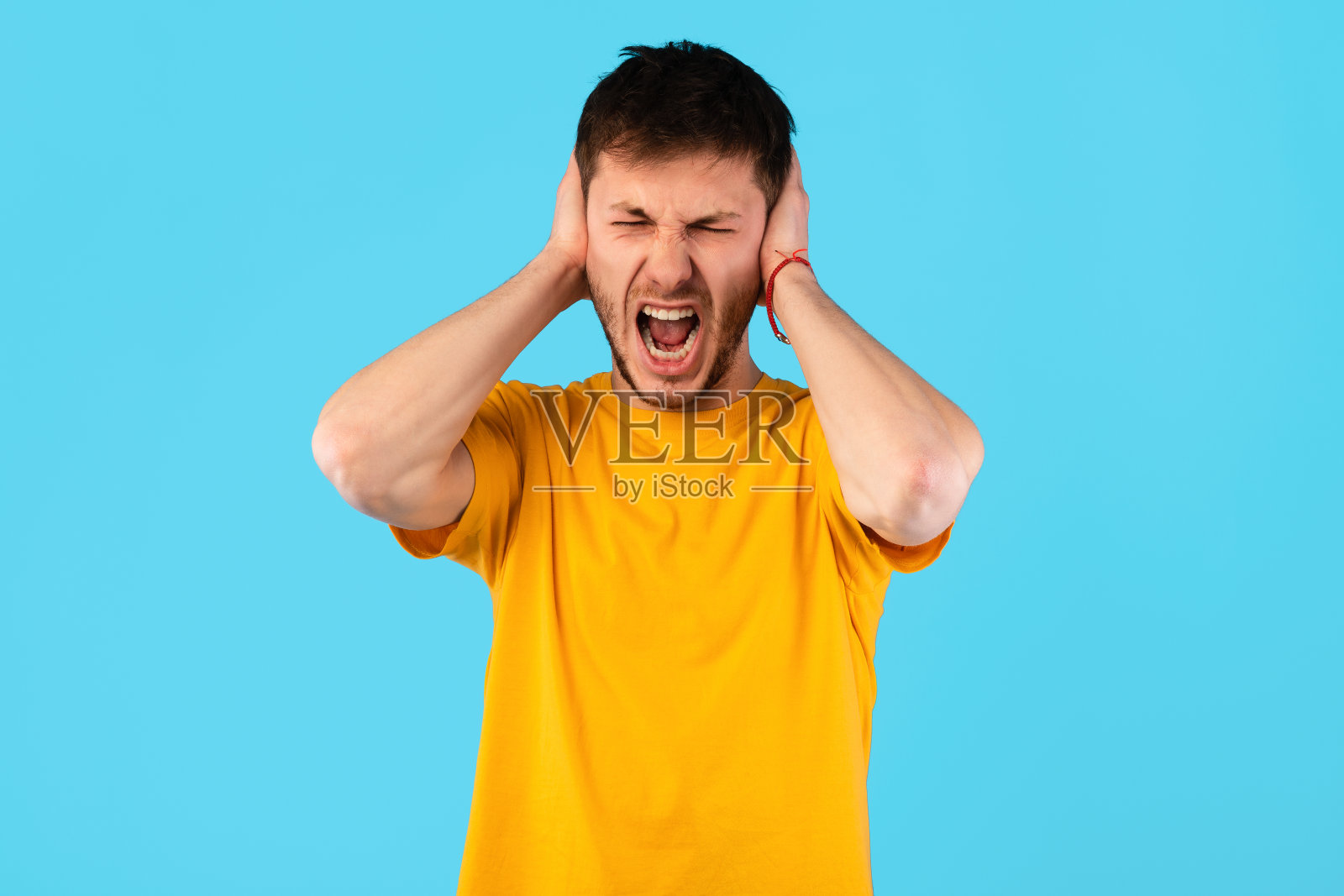 愤怒的年轻人一边尖叫一边抓着头照片摄影图片