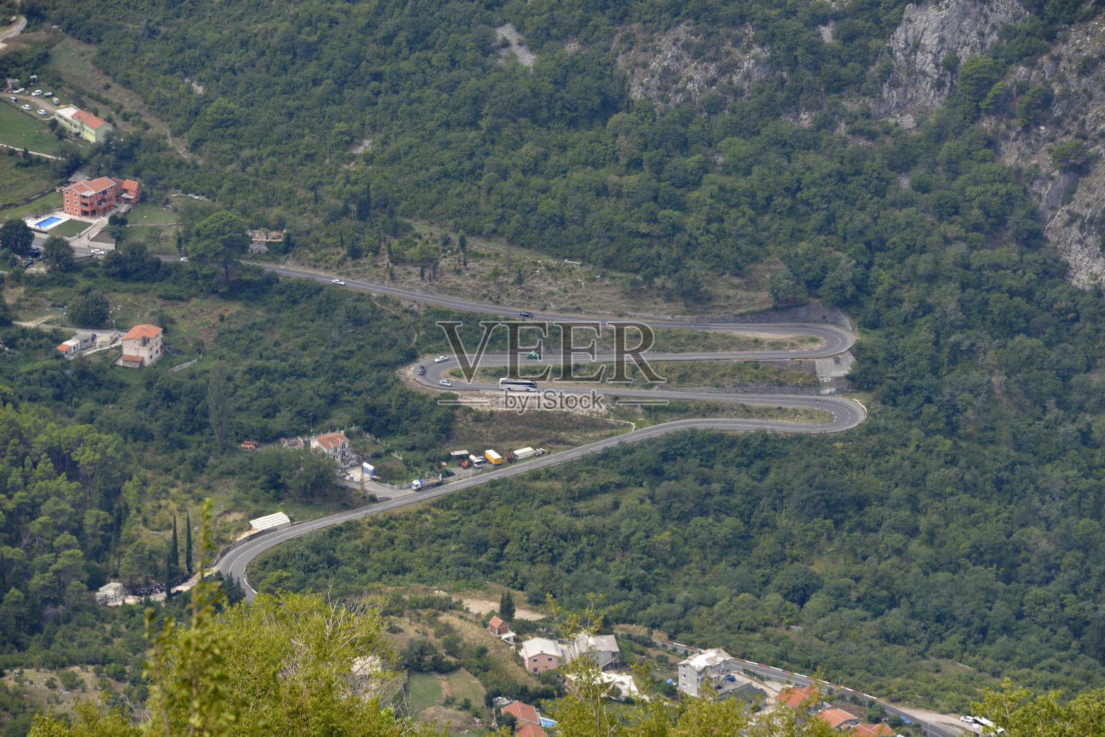 弯弯曲曲的路沿着陡峭的山坡,呈字母M的形状。照片摄影图片