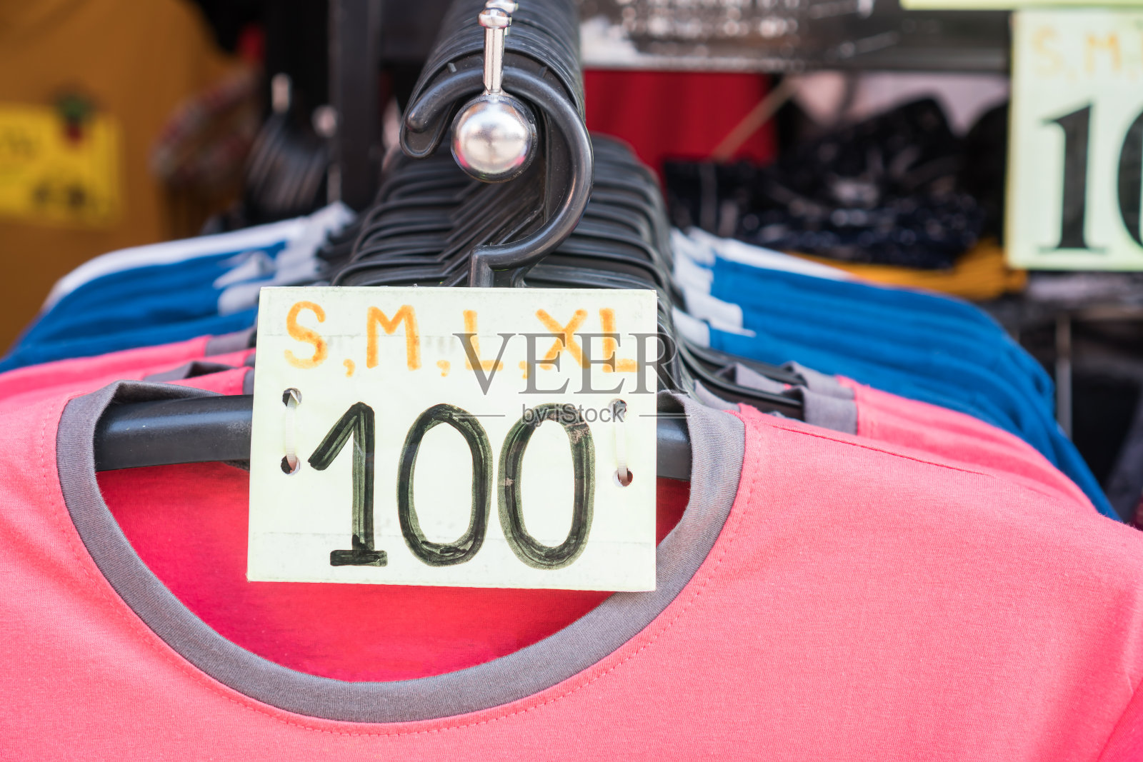 衣服挂在塑料衣架上,价格和尺寸的t恤在货架上流行出售,店前商店收集供顾客选择,零售在商店商店在百货中心,生活方式在消费主义照片摄影图片