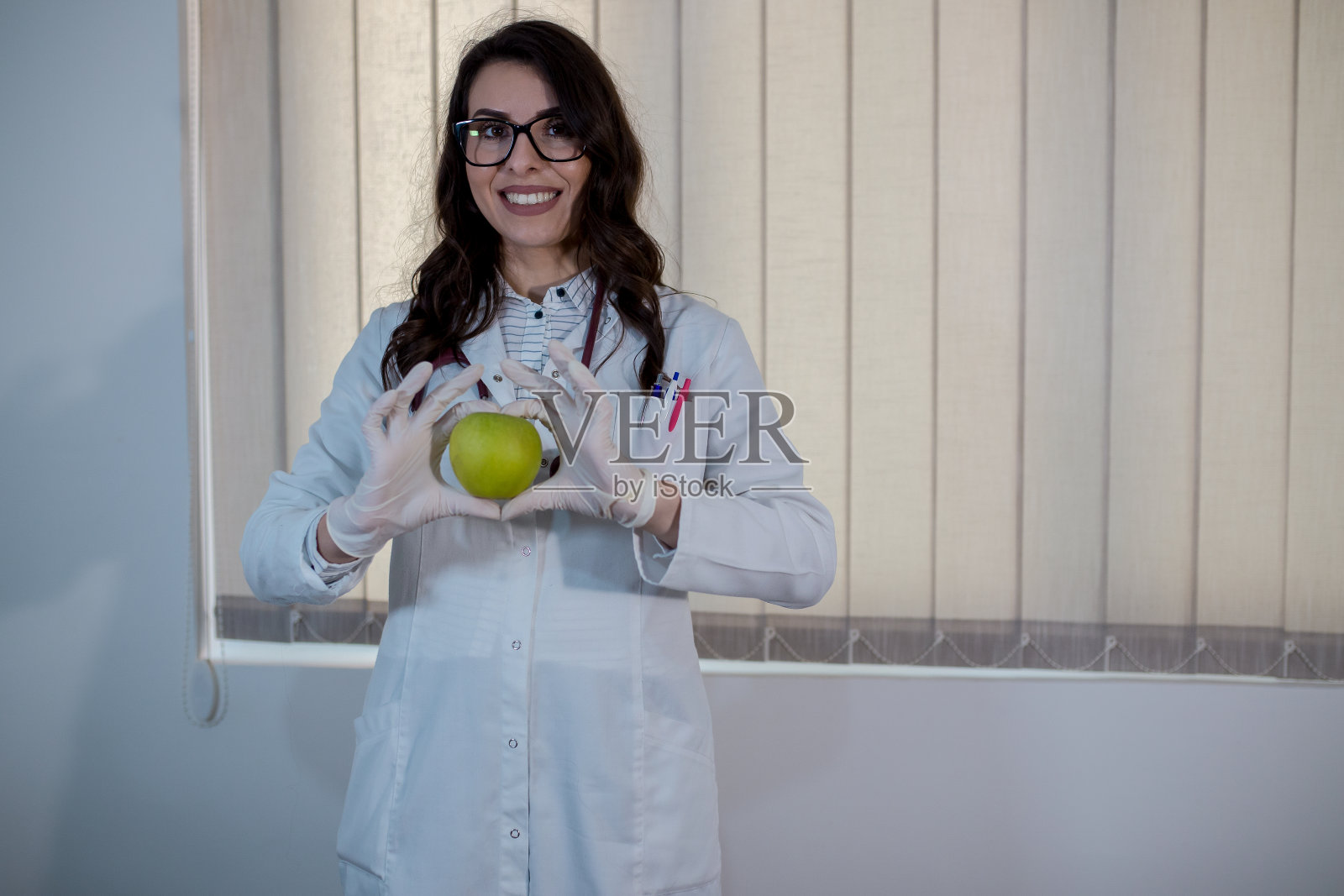 医生女孩与听诊器和青苹果照片摄影图片