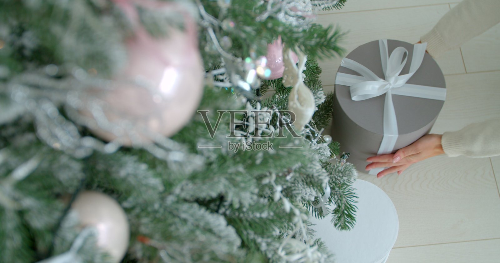 女人把礼物放在圣诞树下。圣诞节前夕,微笑的妻子在客厅里制造惊喜。肖像快乐女性离开礼物在新年装饰公寓。照片摄影图片