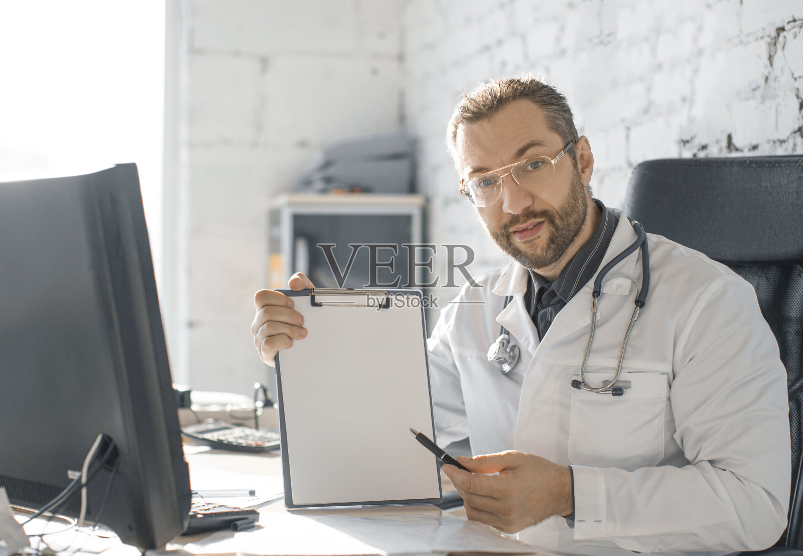 医生用一支笔指着写字板照片摄影图片