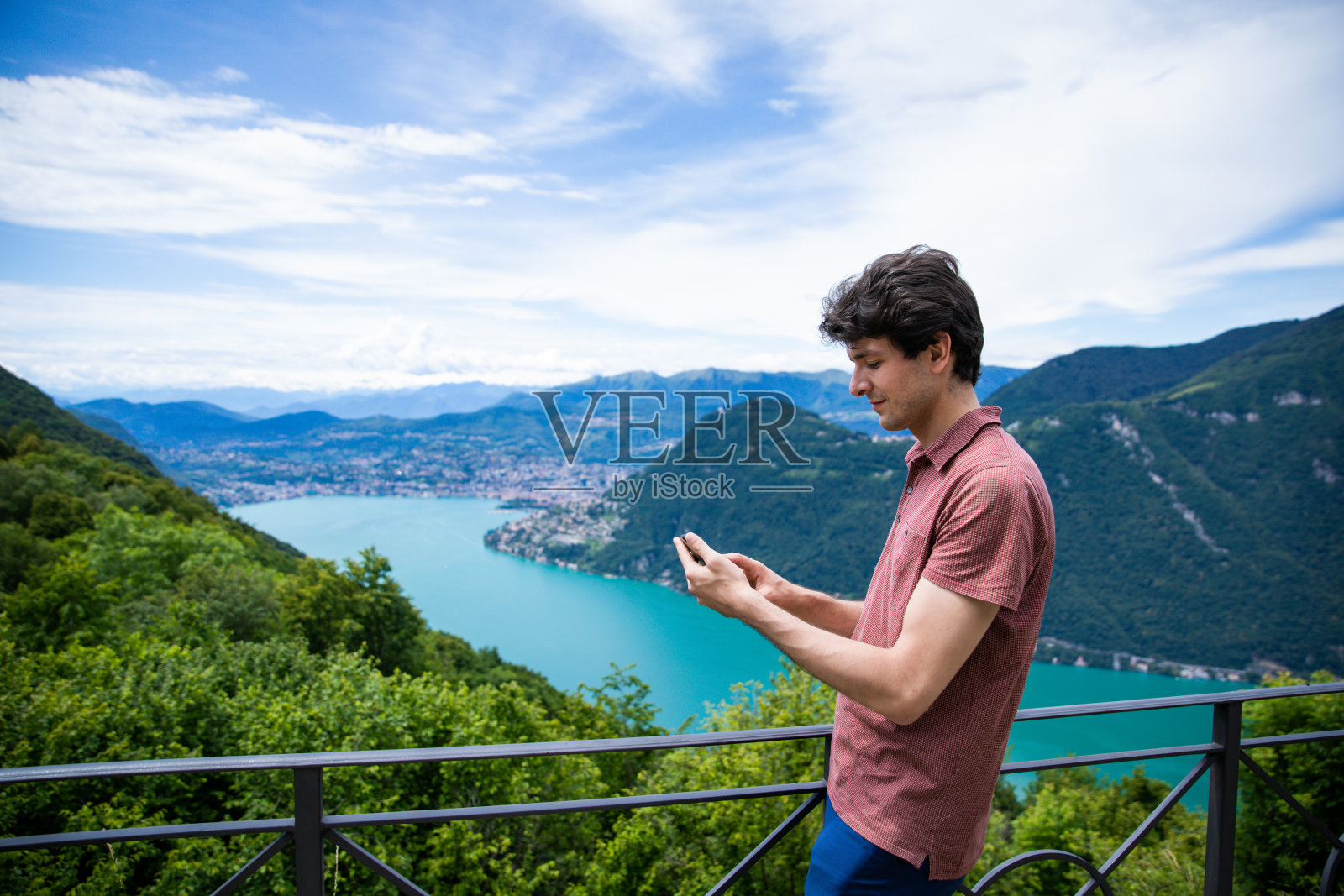 一名男子在卢加诺的美丽景色中使用手机照片摄影图片