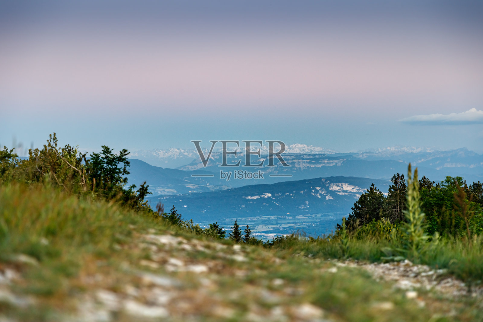 在春天的晚些时候,在法国阿尔卑斯山脉中部的山顶徒步旅行的土路照片摄影图片