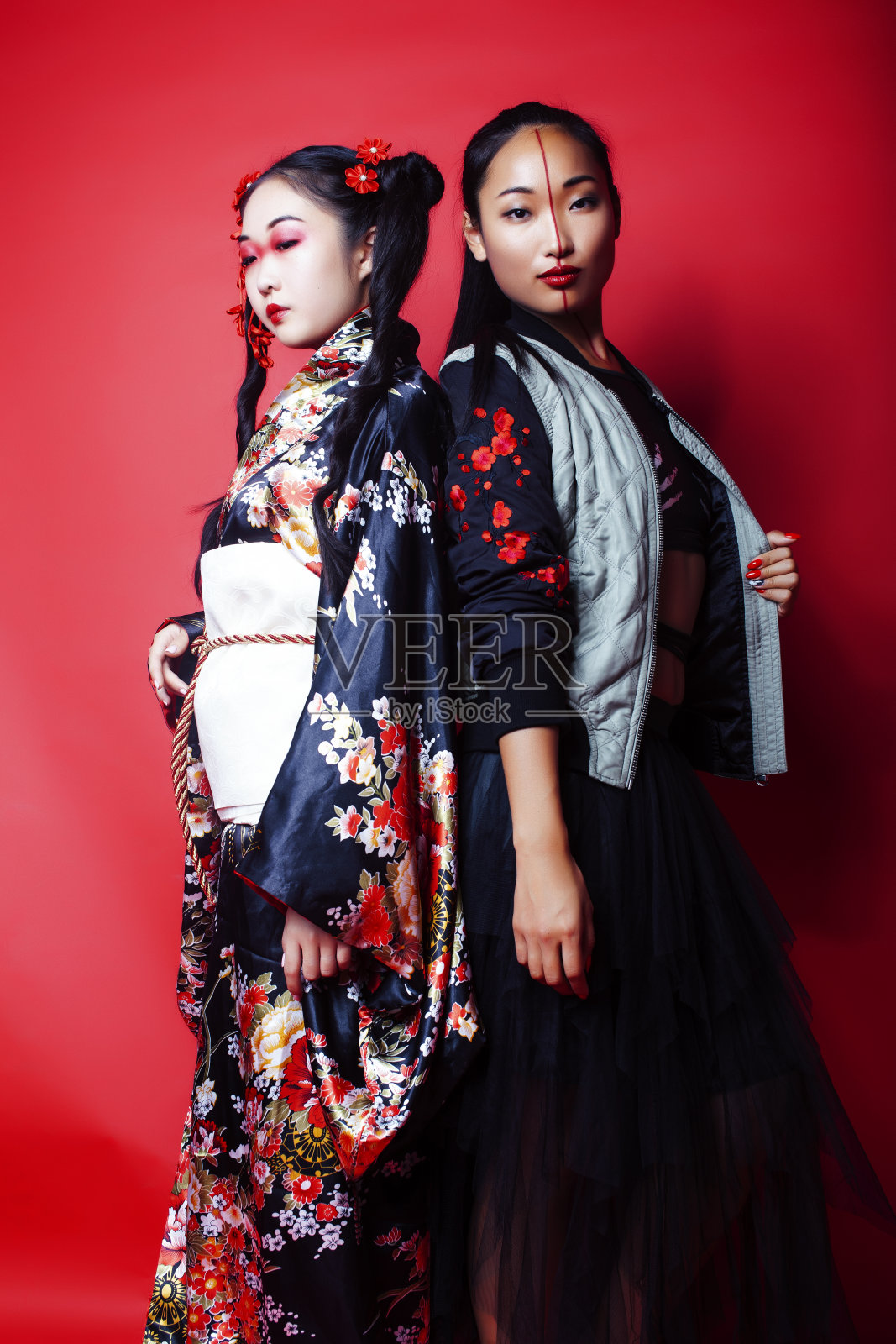 两个漂亮的艺妓朋友:现代亚洲女性和传统穿着和服摆出欢快的红色背景照片摄影图片
