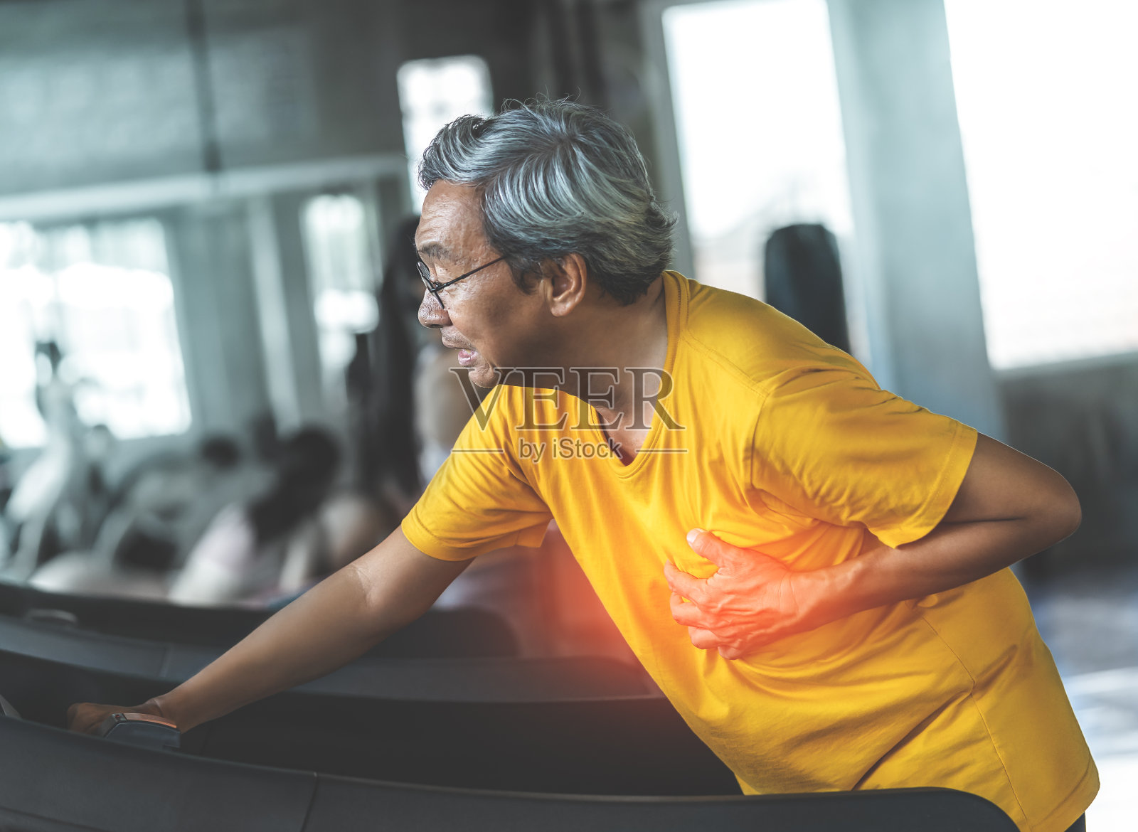 一名老年男性在跑步机上锻炼时心脏病发作照片摄影图片