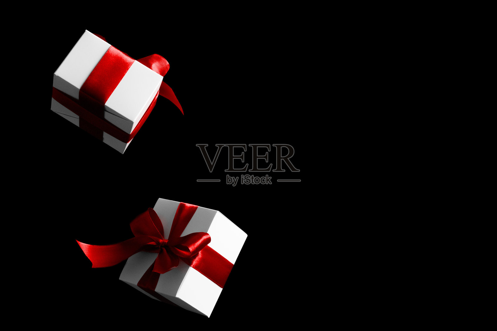 在线的圣诞节。在黑色星期五的概念中,白色礼盒与红色丝带隔离在黑色背景上。文本的装饰和复制空间。照片摄影图片
