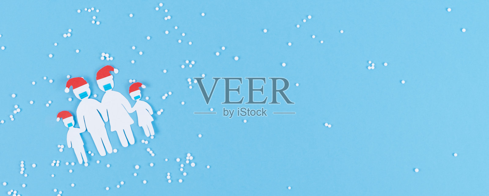 家庭剪纸与面具和圣诞帽在蓝色背景与圣诞装饰。照片摄影图片