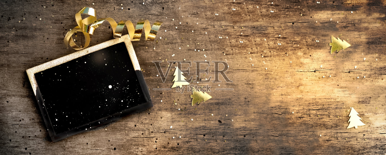 小板上的乡村木制背景与金色的五彩纸屑和丝带照片摄影图片