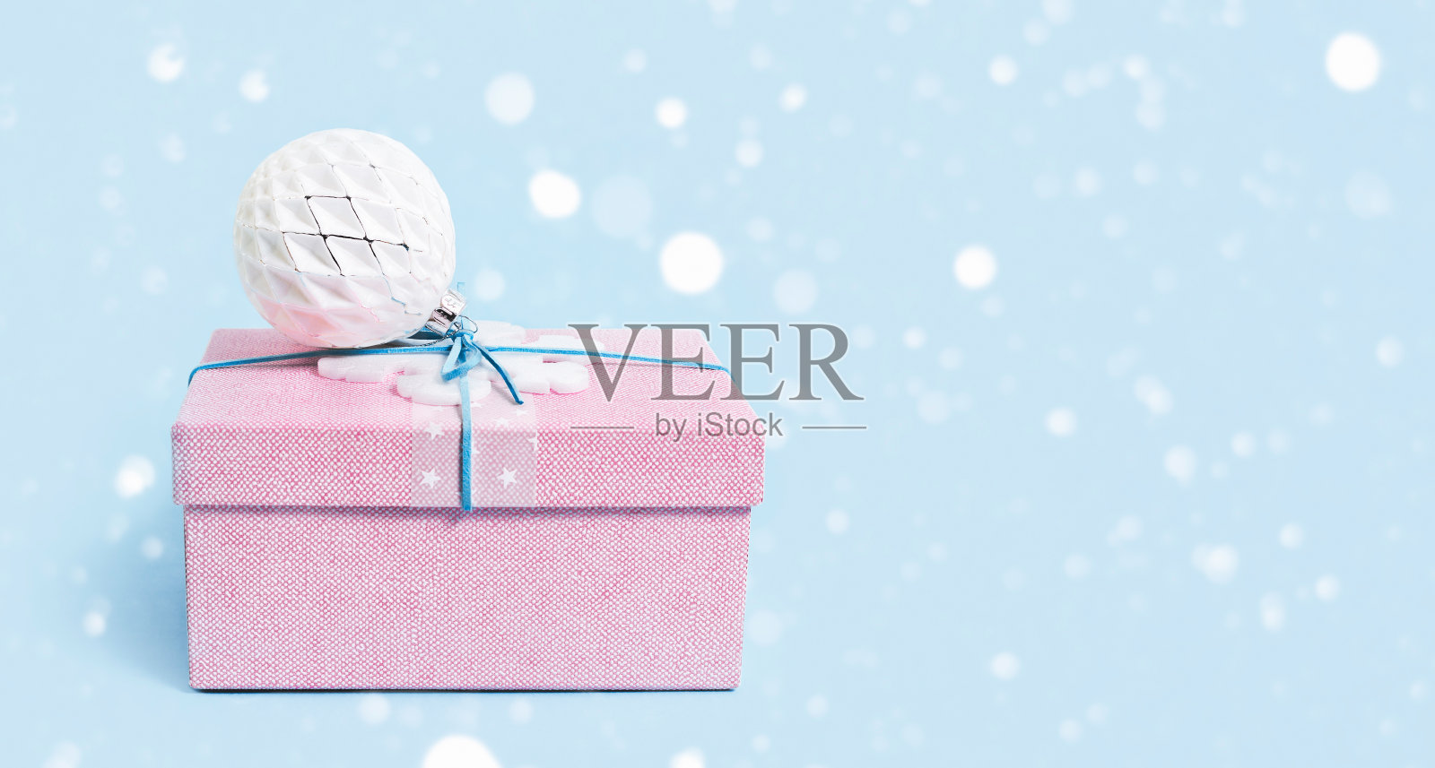 红色的圣诞礼盒,白色的小装饰品,蓝色的照片摄影图片