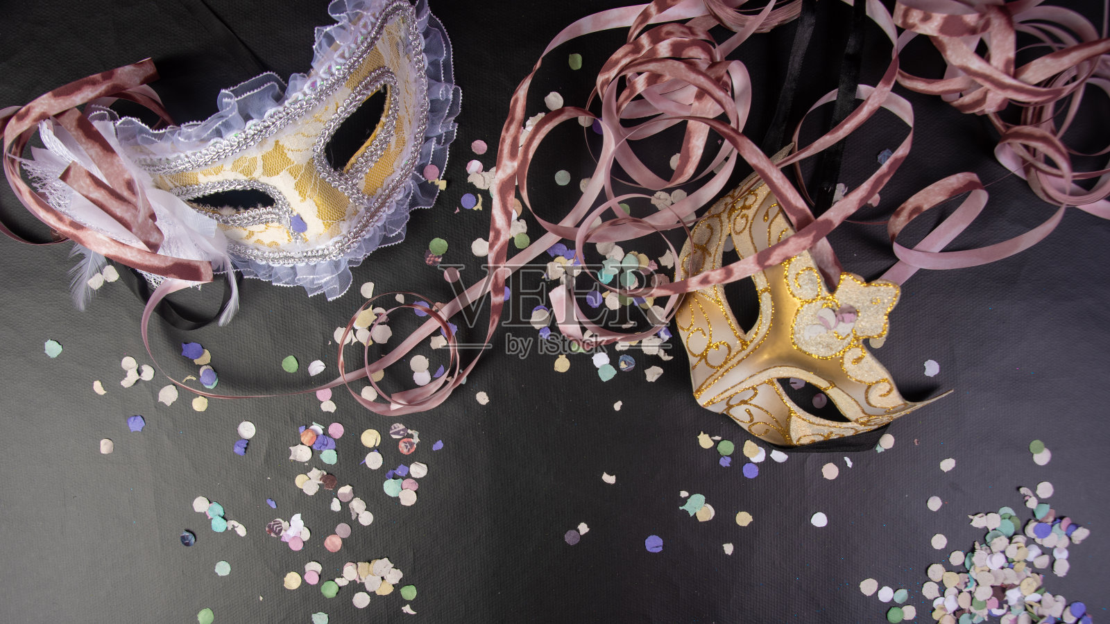 来自巴西的威尼斯面具和狂欢节道具排列在黑色表面,俯视图。照片摄影图片