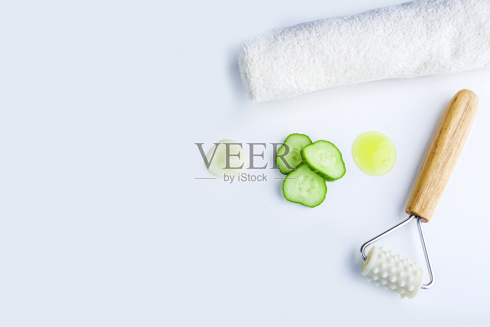 Spa面部护理套装:黄瓜片、面膜、毛巾、按摩器。黄瓜洁面及保湿化妆品。天然有机成分自制美容产品照片摄影图片