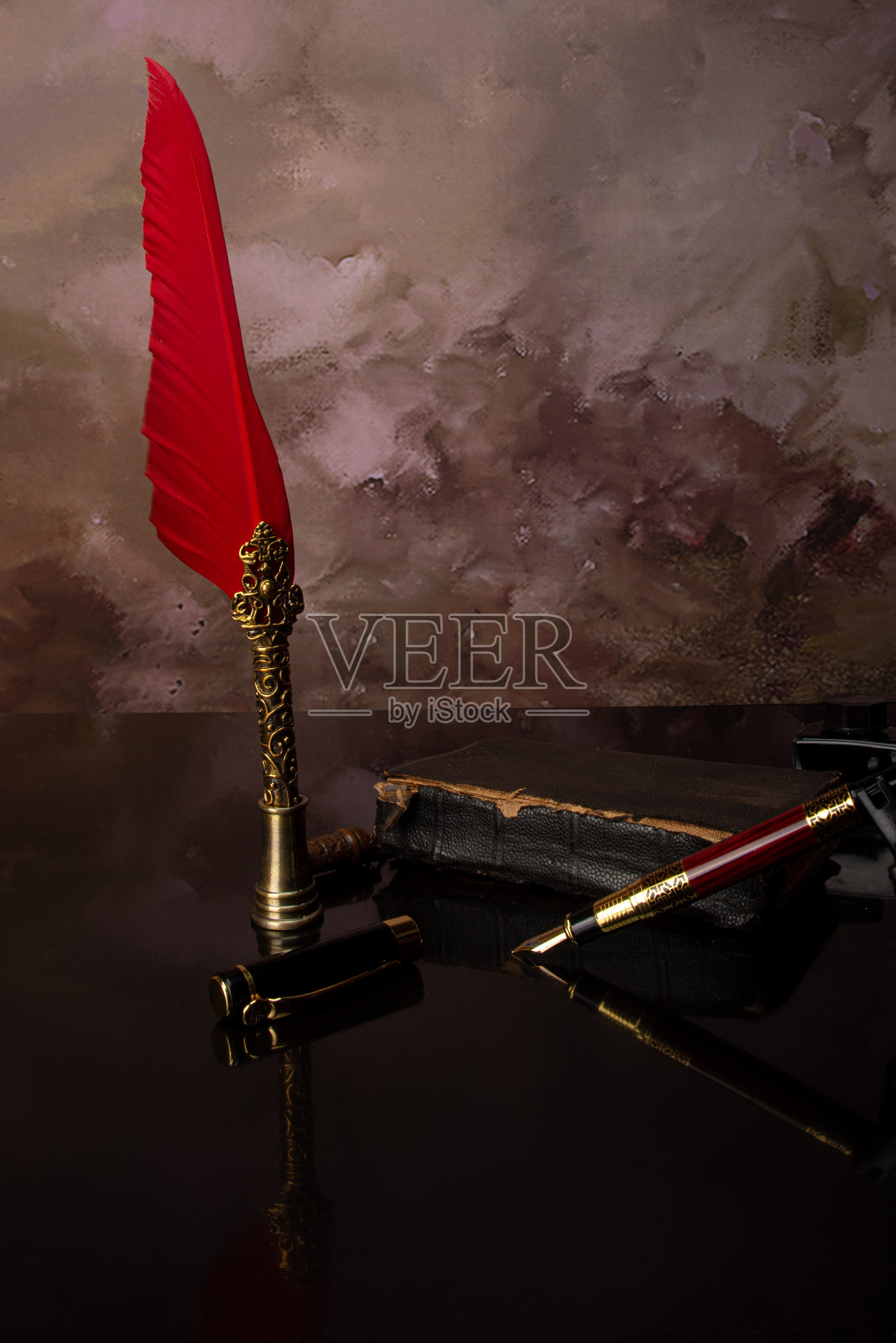 镜面上的钢笔和旧书,背景模糊,选择性聚焦。照片摄影图片