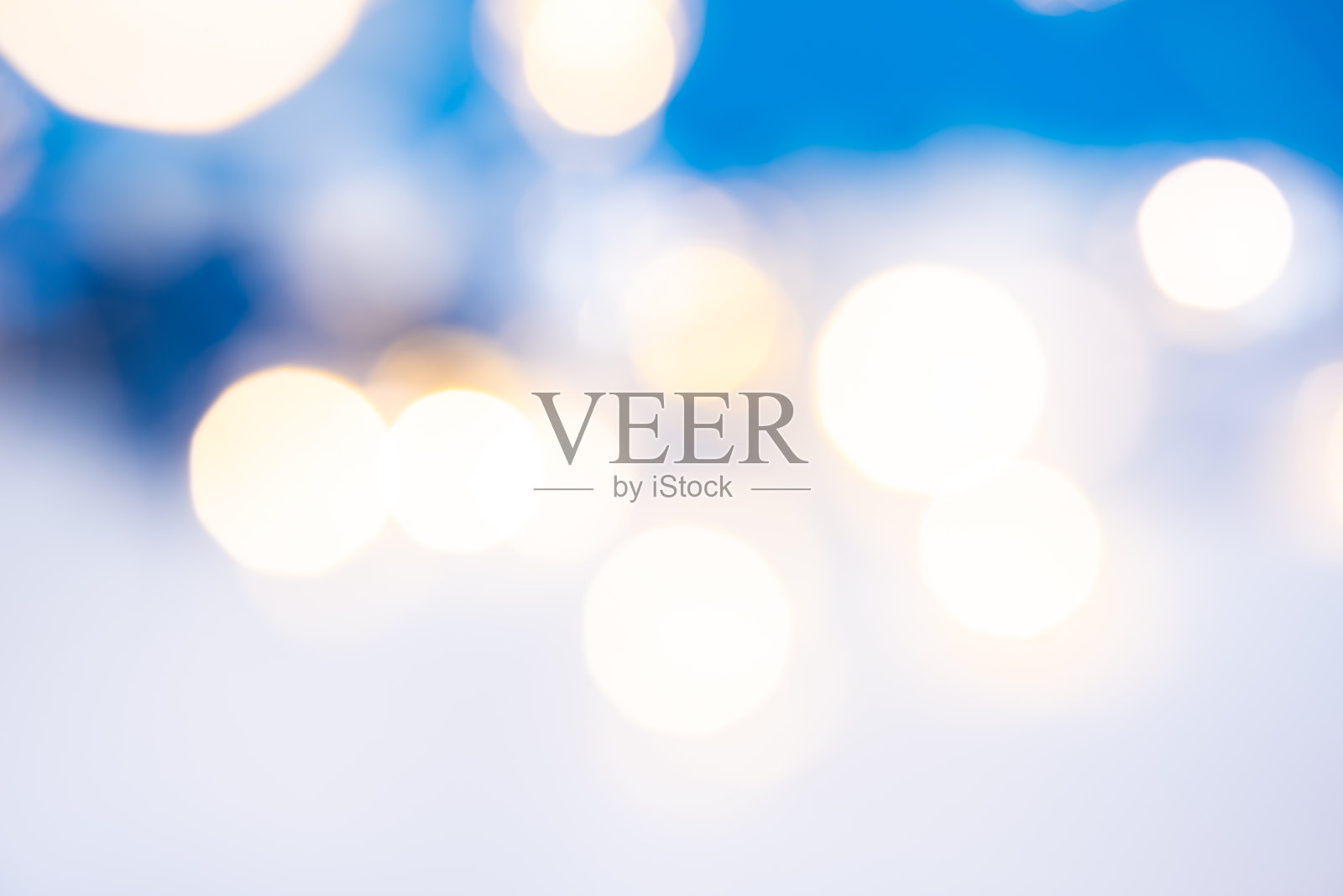 摘要圣诞散景背景。白色和蓝色背景上的金色散焦圆照片摄影图片