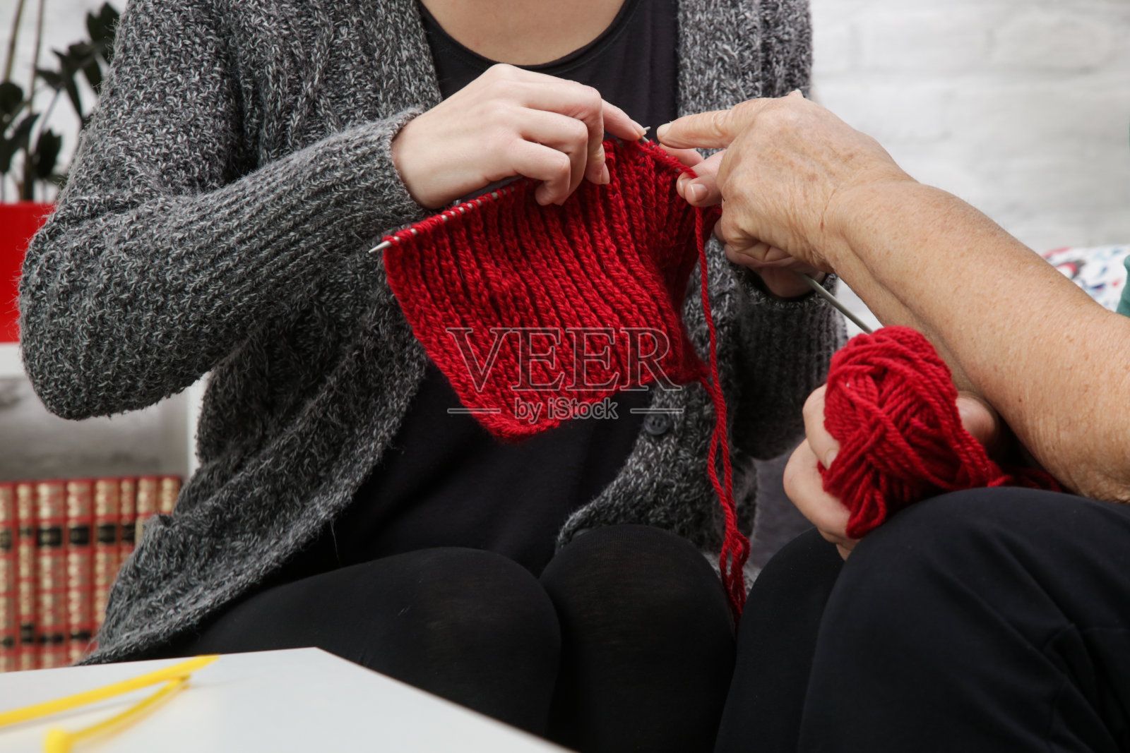 祖母和孙女一起度过有质量的时间,以创造性和有趣的方式,同时加强他们的家庭纽带。年长的女人教年轻的女人如何编织。手工和DIY的概念。照片摄影图片