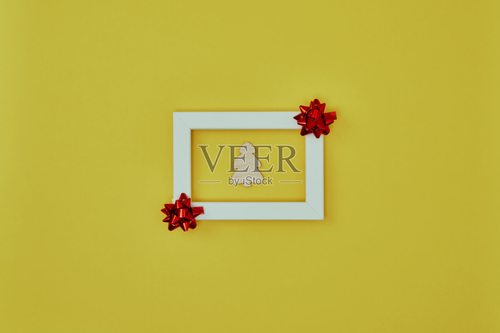 白色框架与圣诞装饰和一棵圣诞树在里面的黄色背景。新年的背景。复制空间,模拟照片摄影图片