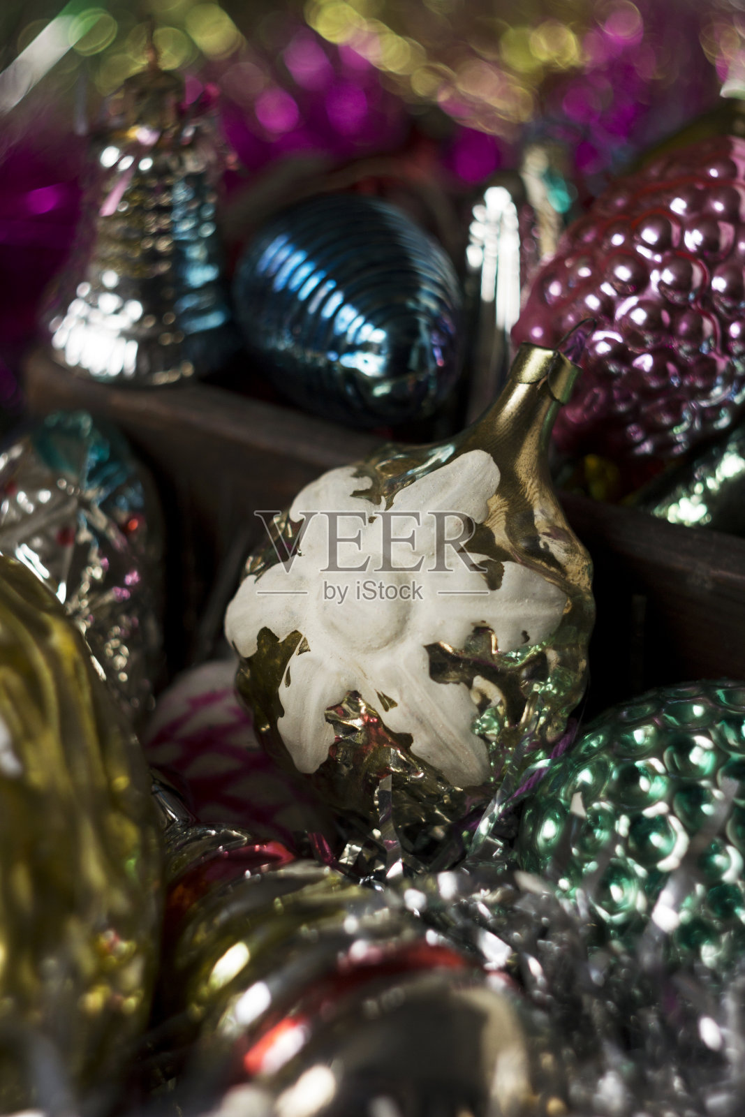 苏联时期的老式新年玩具以雪花、锥形和其他人物的形式出现。粉色、蓝色和金色的玩具放在一个木制的盒子里作为圣诞树。背景照片摄影图片