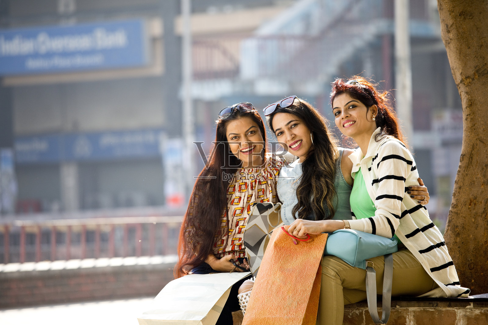 三个女人拿着购物袋坐在城里照片摄影图片