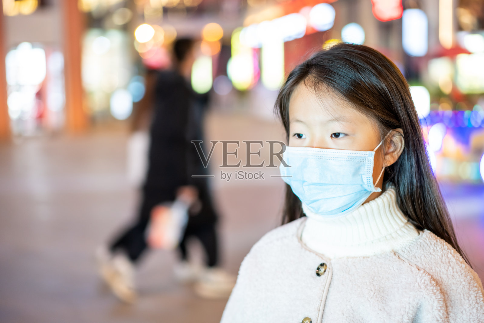 可爱的亚洲小女孩戴着口罩在城市街道上照片摄影图片