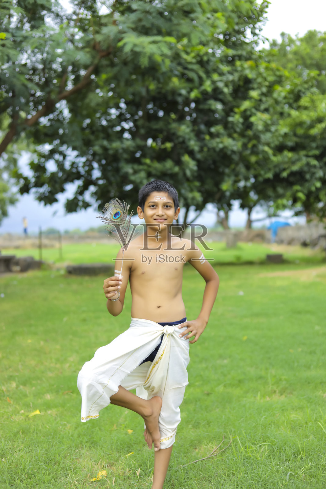 小印度男孩假扮克里希纳神照片摄影图片