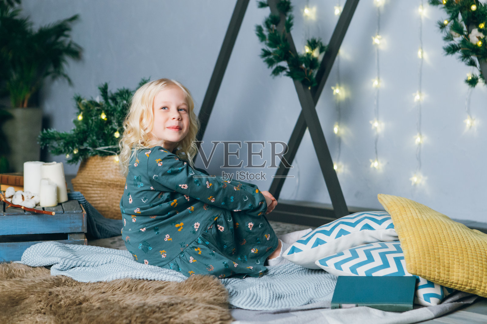 可爱的金发小女孩在圣诞树前摆姿势照片摄影图片