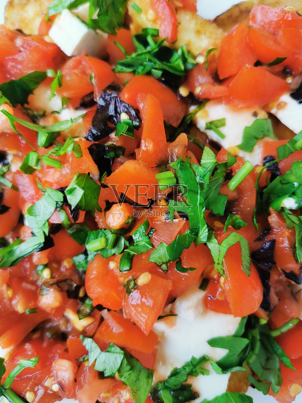 炸西葫芦配软嫩芝士,淋上蕃茄和蒜蓉汁,以罗勒和欧芹调味照片摄影图片