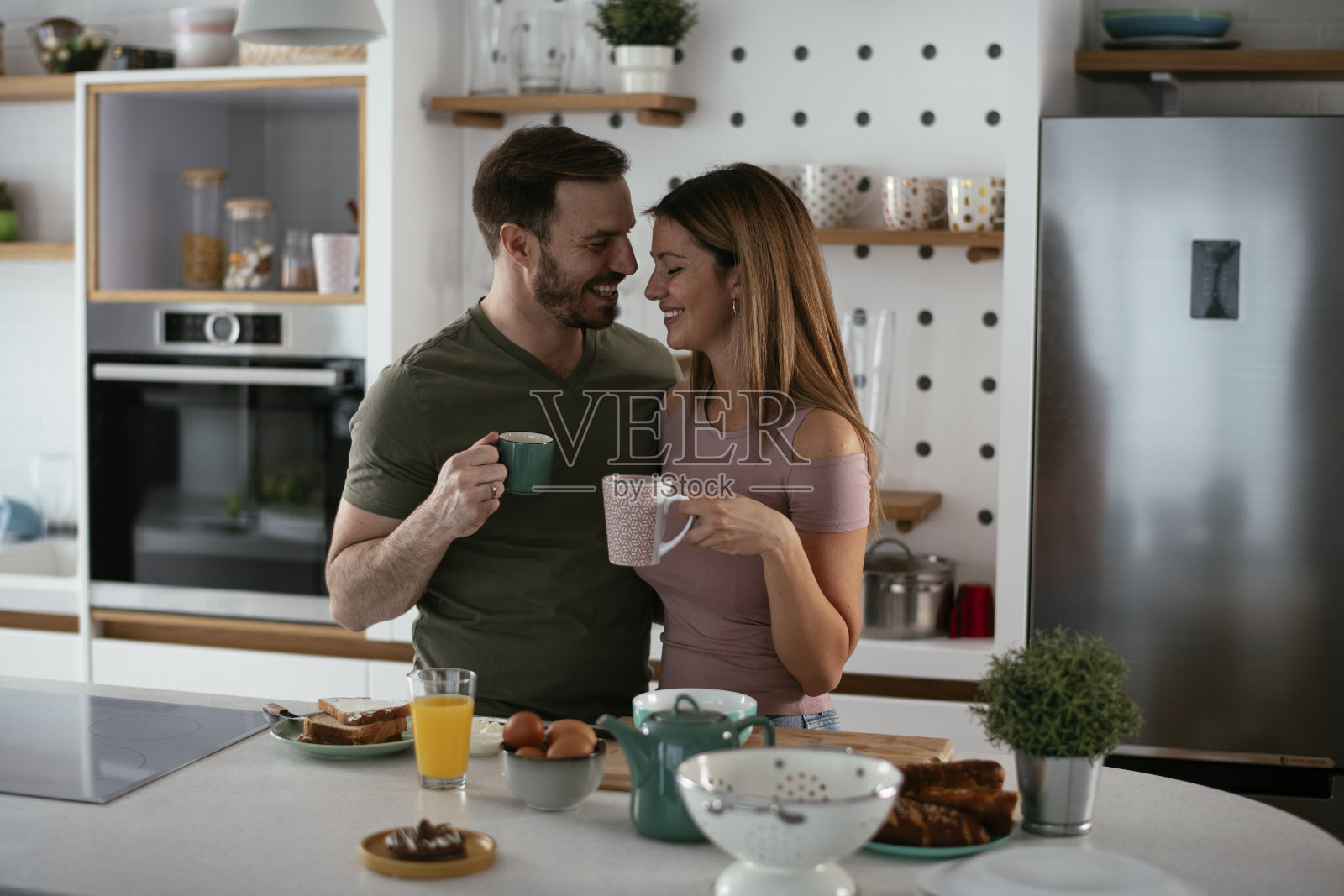 年轻夫妇在家里做三明治。照片摄影图片