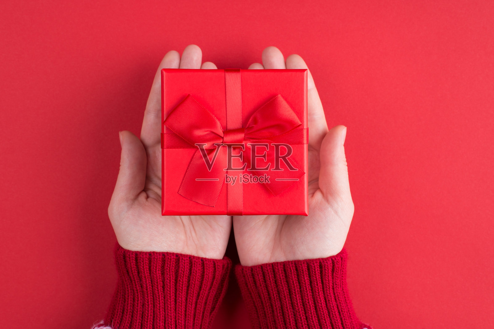 送礼物给朋友的概念。上面的头顶上近距离第一人称查看照片的女人抱着小弓小盒子孤立的明亮的颜色背景照片摄影图片