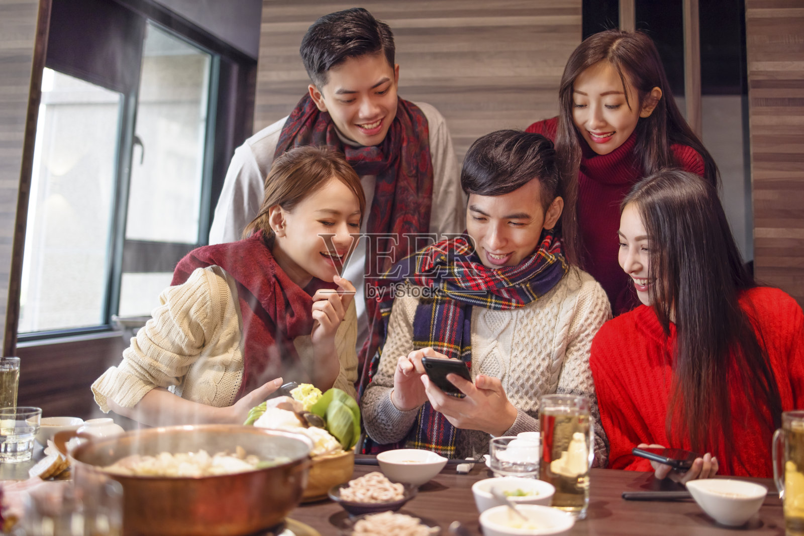 快乐青年组在餐厅看智能手机照片摄影图片