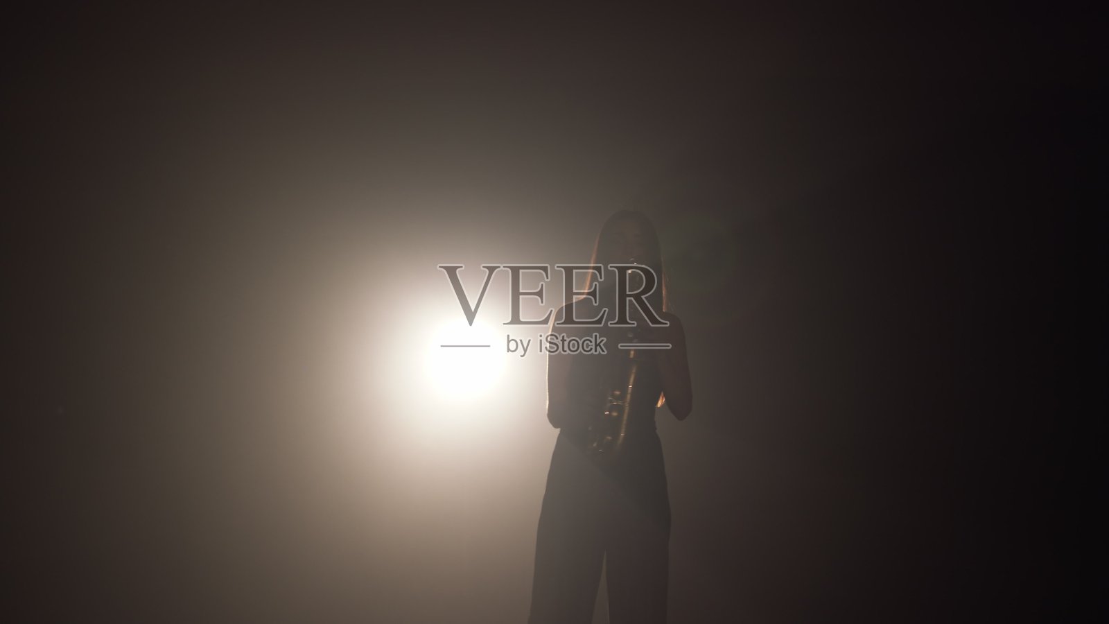 年轻美丽的女孩在舞台上弹奏着金色闪亮的萨克斯管。黑暗的工作室与烟雾和舞台照明。靠近手和萨克斯管。侧视图。慢动作视频照片摄影图片