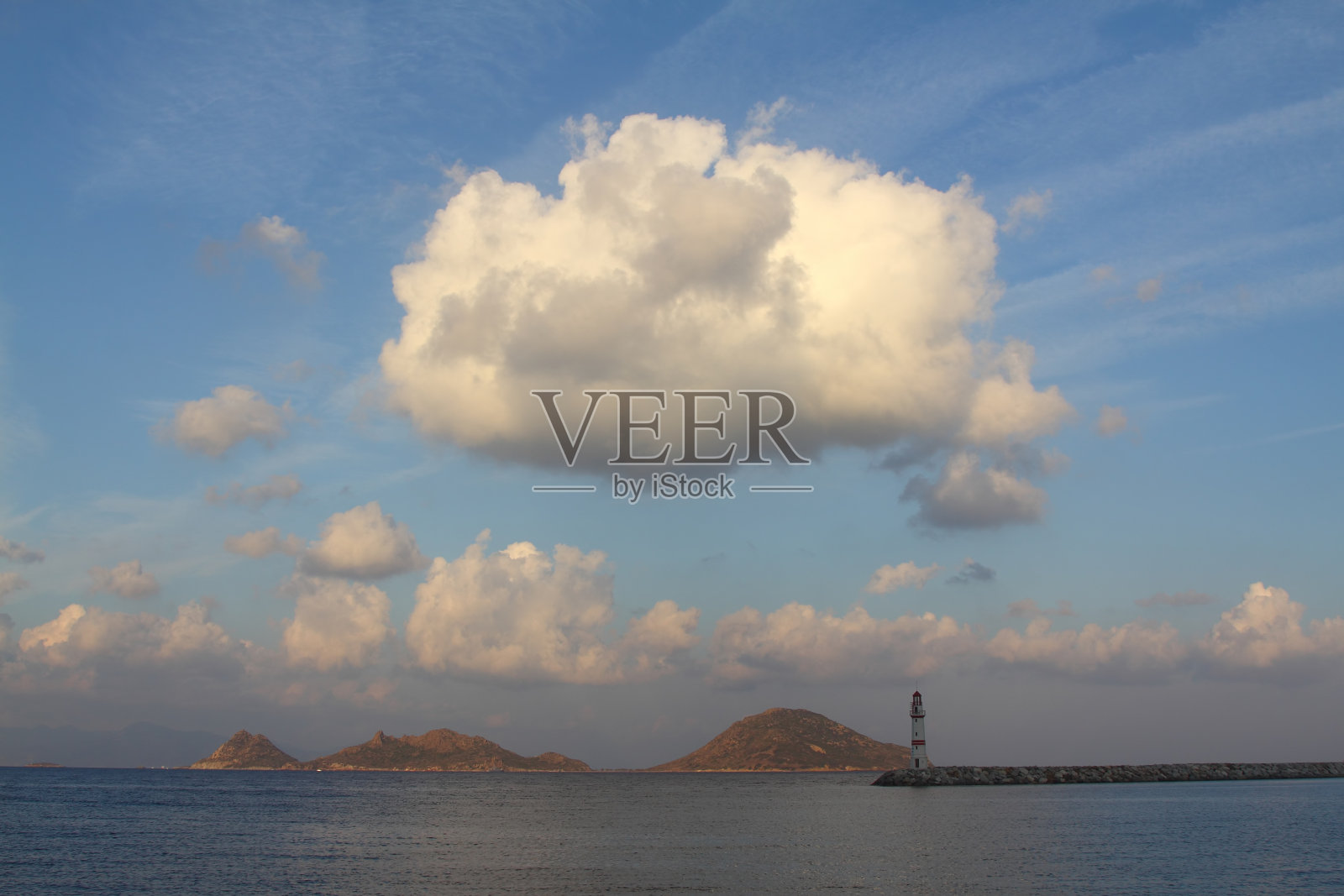 在夕阳海景。海岸上的灯塔。海边小镇Turgutreis和壮观的日落照片摄影图片